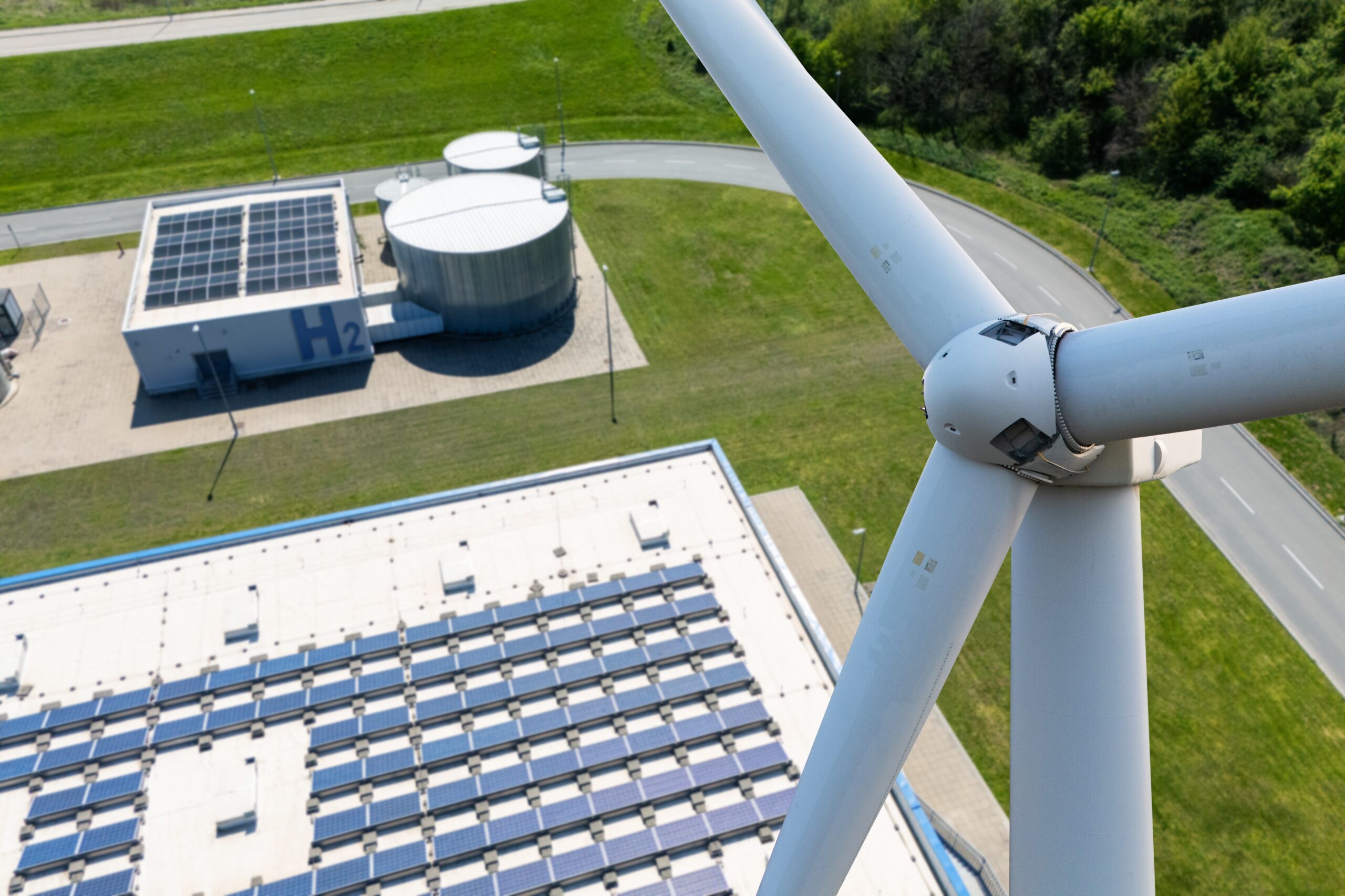 Close-up,Of,Wind,Turbine,With,Green,Hydrogen,Production,Plant,In